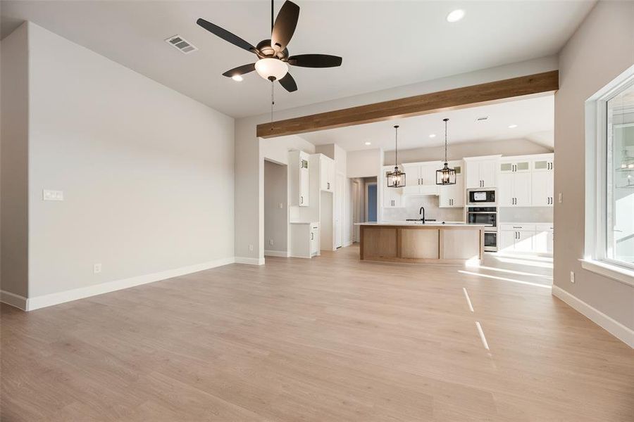 Unfurnished living room featuring light wood-type flooring, ceiling fan, and recessed lighting Unfurnished living room featuring light wood-type flooring, ceiling fan, and recessed lighting