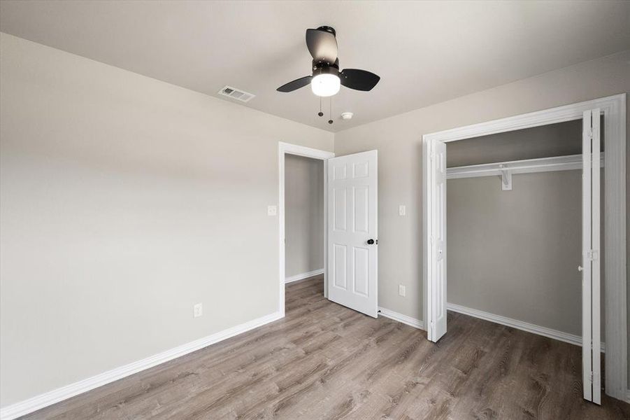 Bright interior space featuring wood-finish flooring, light neutral wall paint, and white baseboards