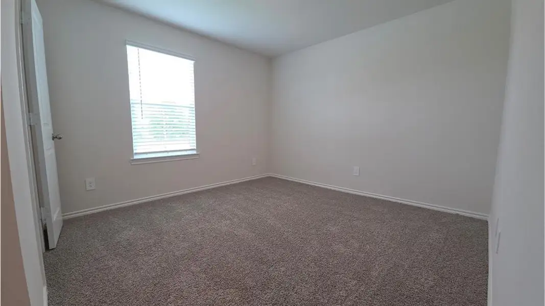 Carpeted room with a single window featuring horizontal blinds