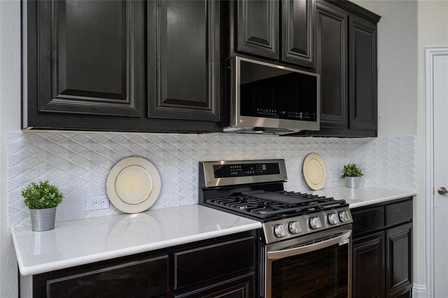 Kitchen with tasteful backsplash and stainless steel appliances