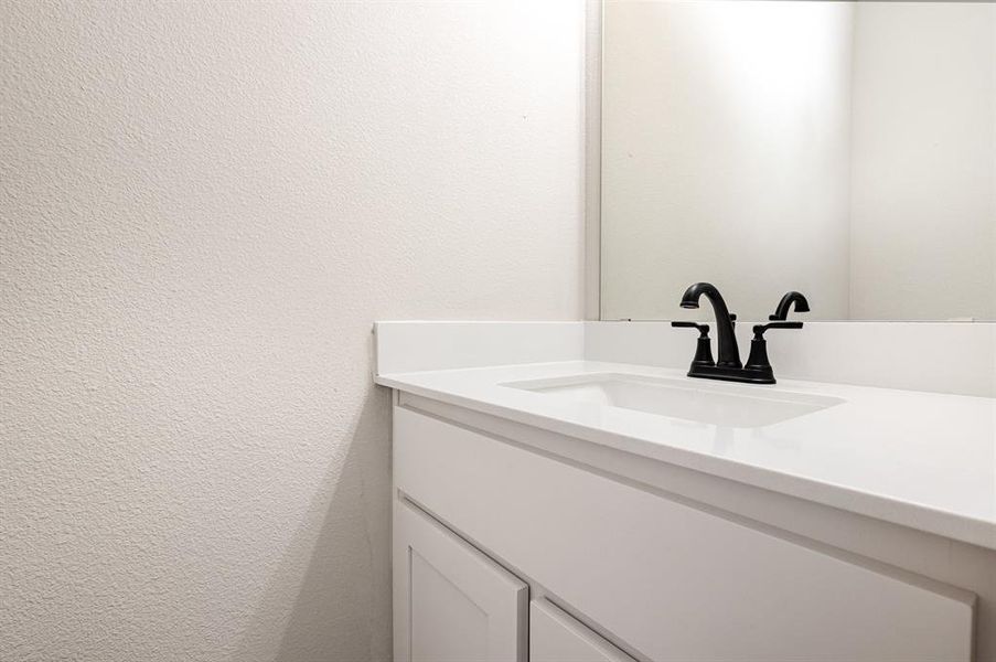 Bathroom featuring vanity and a textured wall