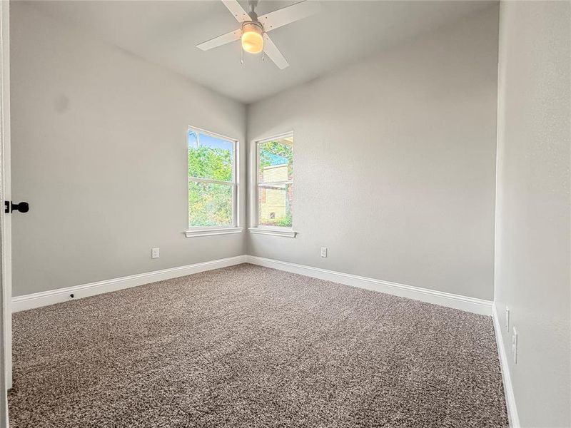 Neutral-toned interior room featuring light gray walls, plush brown carpeting, and white baseboards