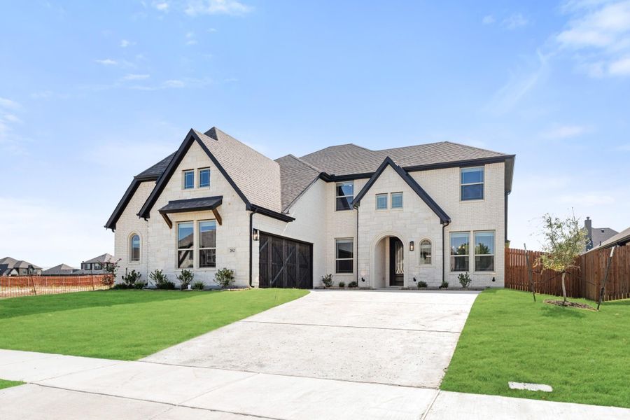 Two-story white brick home with dark trim, two-car garage, arched entry, and green front lawn. Two-story white brick home with dark trim, two-car garage, arched entry, and green front lawn.
