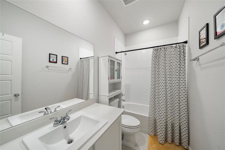 Full bathroom featuring shower / bath combo, toilet, and sink