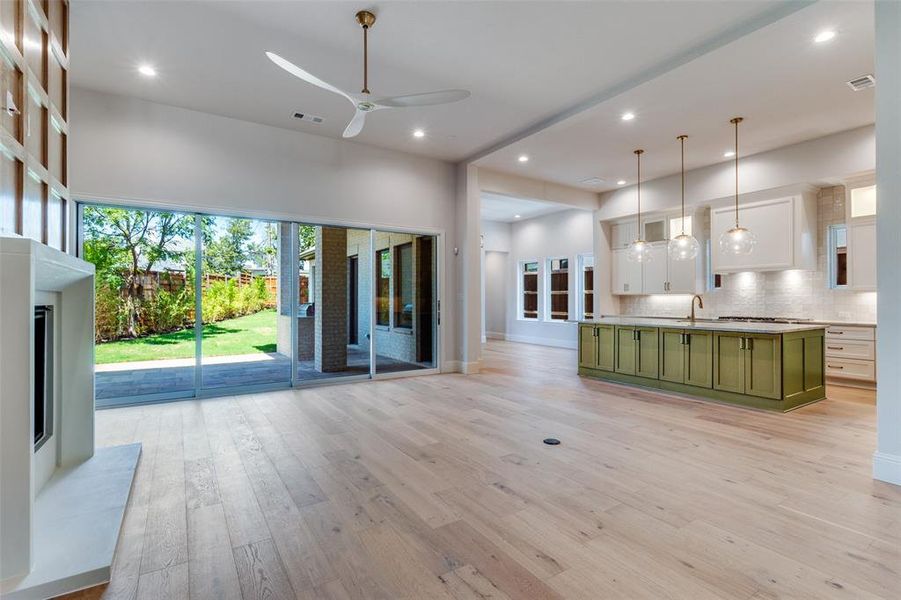 Unfurnished living room featuring light wood finished floors, healthy amount of natural light, recessed lighting, and a ceiling fan Unfurnished living room featuring light wood finished floors, healthy amount of natural light, recessed lighting, and a ceiling fan