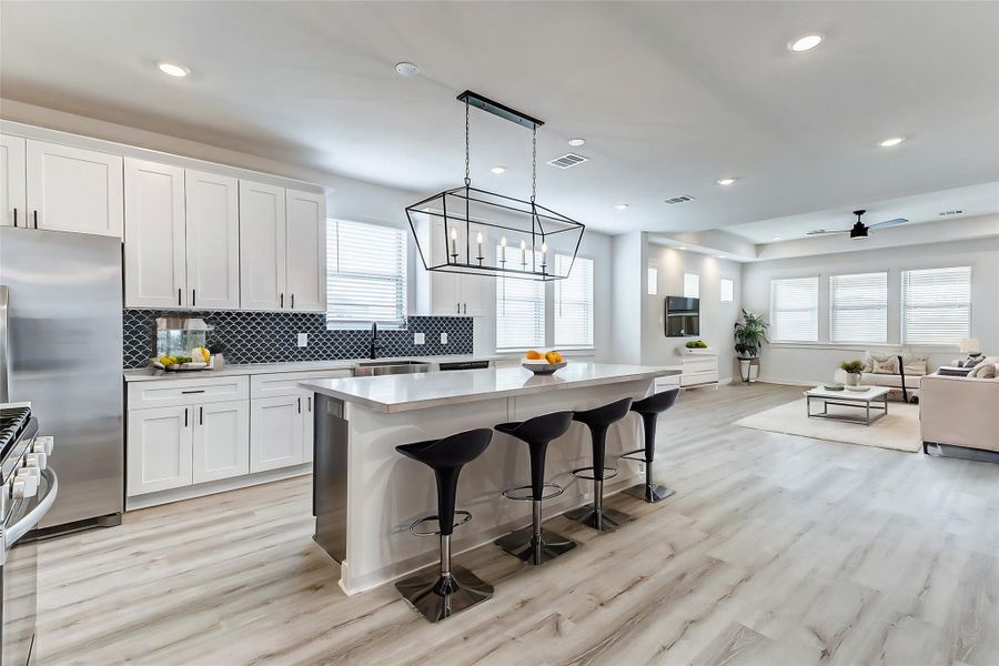 A chef’s dream! This gourmet kitchen boasts an oversized island, stainless steel appliances, pristine white cabinetry, and a stylish backsplash. The perfect place to whip up delicious meals while staying connected to the family. **This is a picture of a Rylan Floor Plan from another Saratoga Homes.** A chef’s dream! This gourmet kitchen boasts an oversized island, stainless steel appliances, pristine white cabinetry, and a stylish backsplash. The perfect place to whip up delicious meals while staying connected to the family. **This is a picture of a Rylan Floor Plan from another Saratoga Homes.**