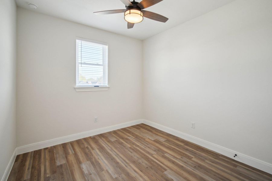 Bedroom 3 with baseboards, ceiling fan, and wood finished floors Bedroom 3 with baseboards, ceiling fan, and wood finished floors