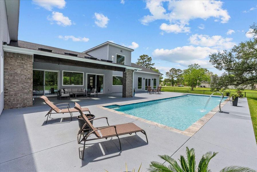 The resort-style pool features dual scupper water features.