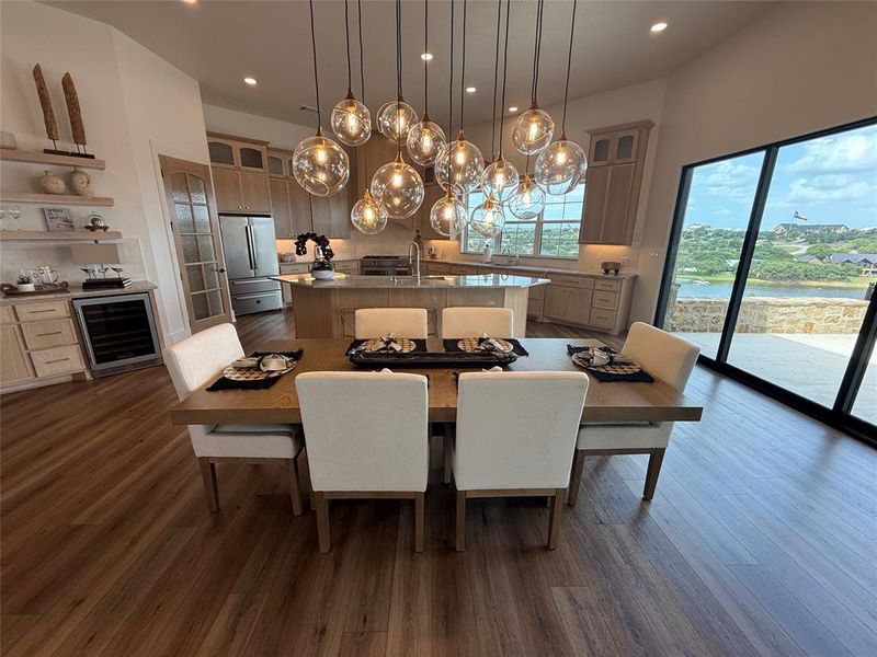 Dining space with wine cooler, dark wood finished floors, recessed lighting, and a chandelier Dining space with wine cooler, dark wood finished floors, recessed lighting, and a chandelier