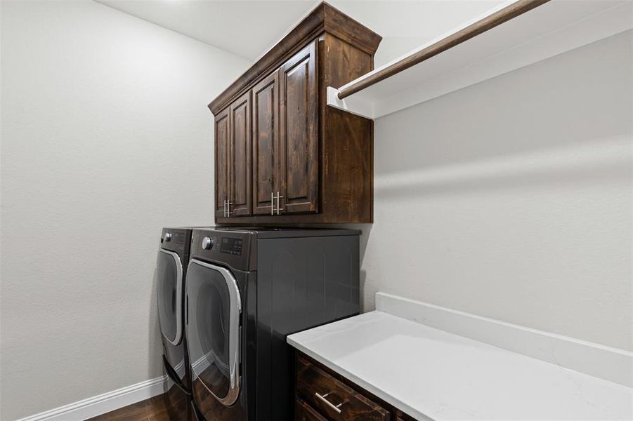 Washroom with dark wood-style floors, independent washer and dryer, and cabinet space Washroom with dark wood-style floors, independent washer and dryer, and cabinet space