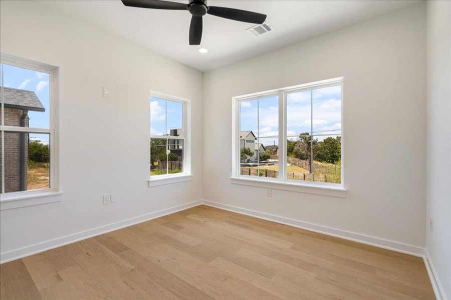 Unfurnished room featuring light wood finished floors, healthy amount of natural light, a ceiling fan, and recessed lighting