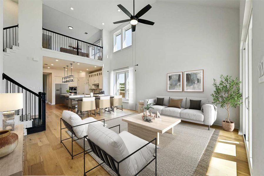 Living area with stairway, a high ceiling, light wood-style flooring, a ceiling fan, and recessed lighting