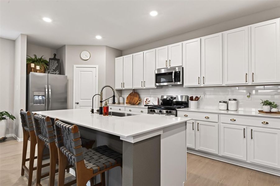 Bright kitchen with ample cabinetry, generous counter space, and a large center island with seating. Bright kitchen with ample cabinetry, generous counter space, and a large center island with seating.