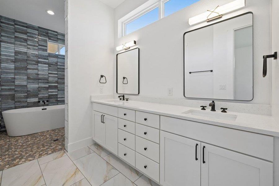 Full bathroom with double vanity, a soaking tub, recessed lighting, and a tile shower