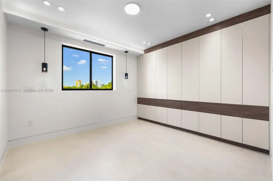 Built-in floor-to-ceiling cabinetry with two-tone finish, large-format tile flooring, dual matte black pendant lights, and recessed ceiling lighting Built-in floor-to-ceiling cabinetry with two-tone finish, large-format tile flooring, dual matte black pendant lights, and recessed ceiling lighting