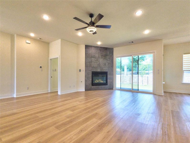 Open-concept living space with wood-finish flooring, recessed lighting, and a ceiling fan