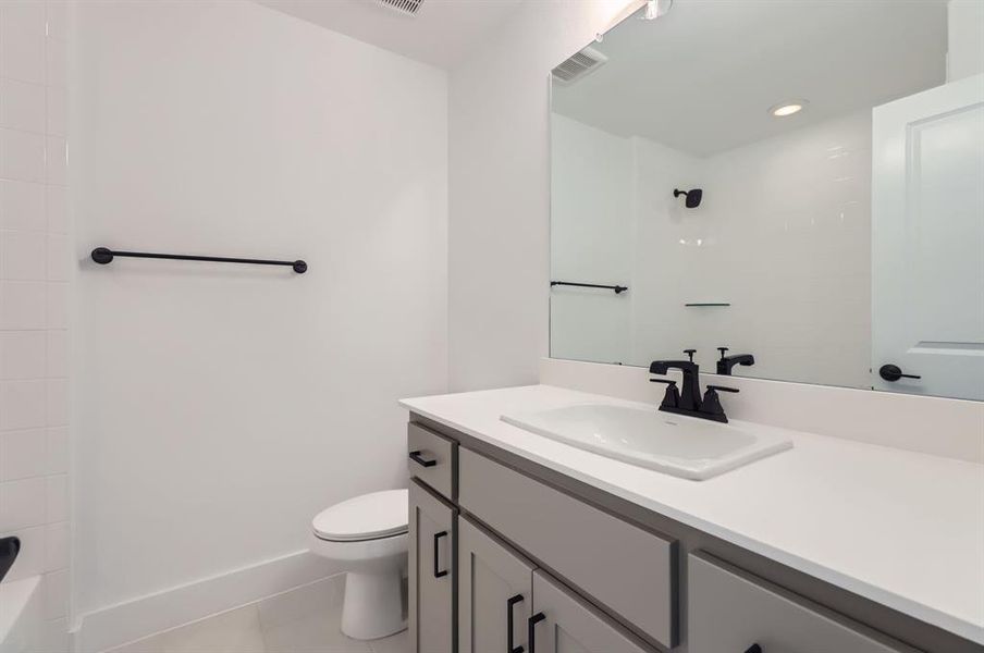 Bathroom featuring vanity, tile patterned floors, and toilet