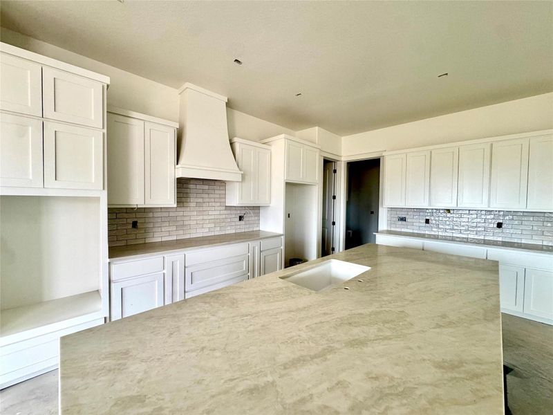 An inviting kitchen with a central island and white cabinetry awaits your culinary creativity.