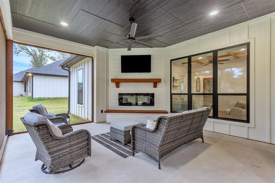 Screened in sunroom with an outdoor living space, fireplace, TV connection and wood accent ceiling. Screened in sunroom with an outdoor living space, fireplace, TV connection and wood accent ceiling.