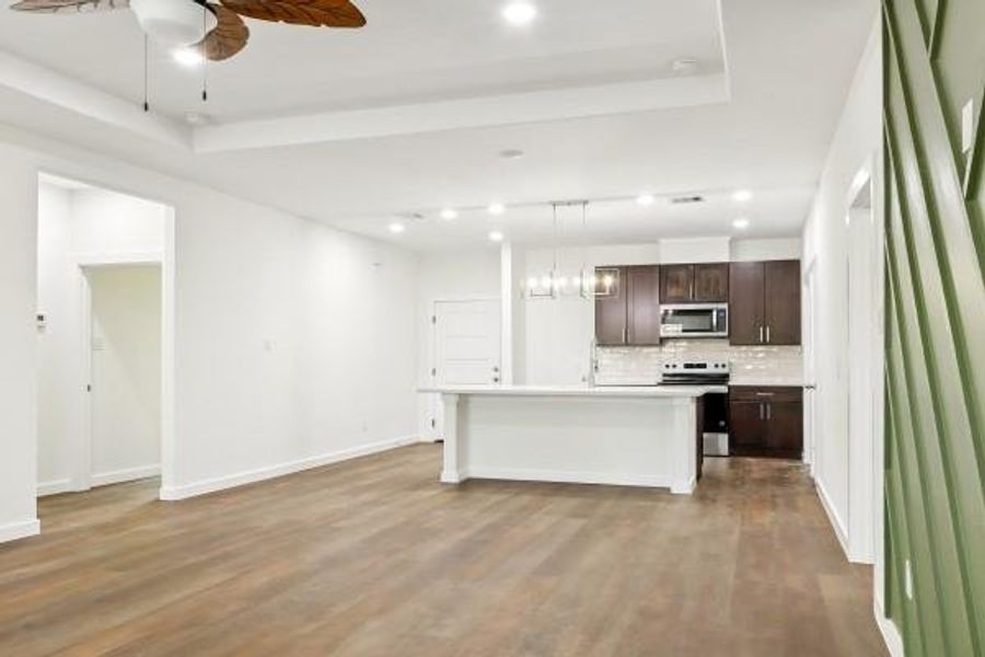 Spacious and inviting living area with modern fixtures, vinyl plank flooring, and an open layout seamlessly connecting to the kitchen. Perfect for entertaining and everyday comfort. Spacious and inviting living area with modern fixtures, vinyl plank flooring, and an open layout seamlessly connecting to the kitchen. Perfect for entertaining and everyday comfort.