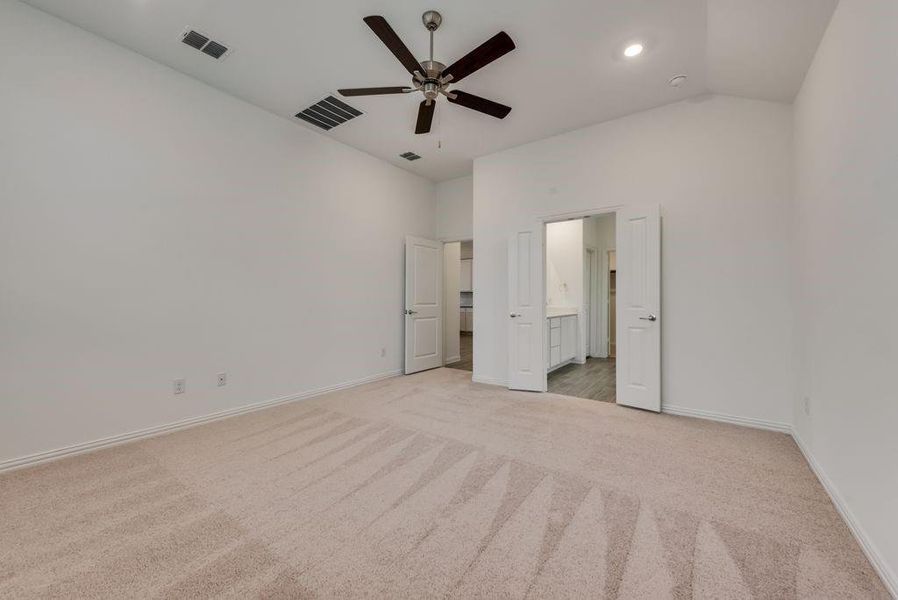 Unfurnished bedroom with carpet flooring, ceiling fan, and lofted ceiling