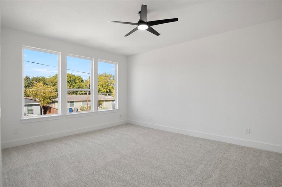 Unfurnished room featuring ceiling fan and carpet flooring