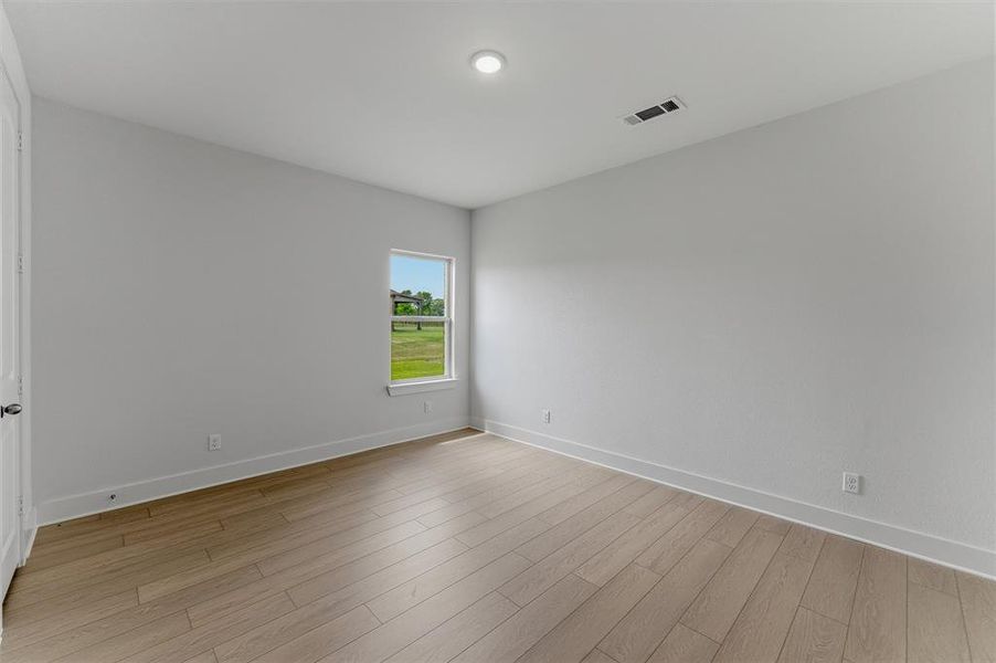 Spacious room featuring light wood-finish flooring, a neutral wall palette, and recessed lighting Spacious room featuring light wood-finish flooring, a neutral wall palette, and recessed lighting