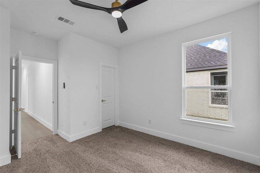Unfurnished bedroom with carpet flooring and ceiling fan Unfurnished bedroom with carpet flooring and ceiling fan