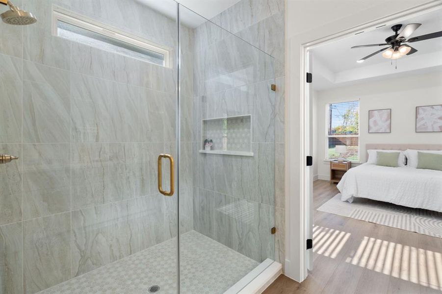 Ensuite bathroom with a stall shower, wood finished floors, and ceiling fan Ensuite bathroom with a stall shower, wood finished floors, and ceiling fan