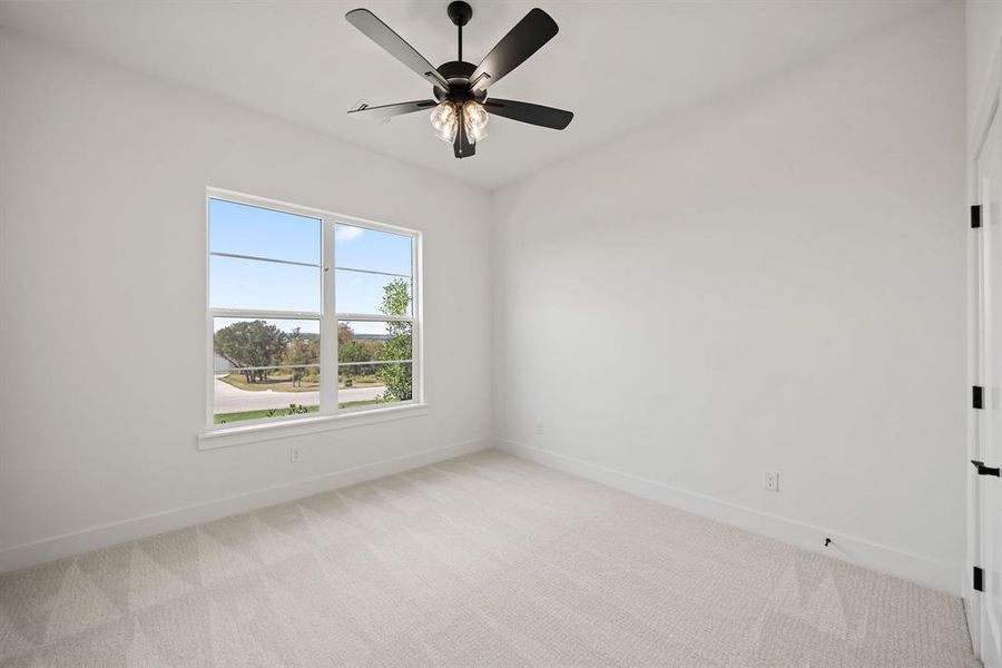 Empty room with light colored carpet and ceiling fan Empty room with light colored carpet and ceiling fan