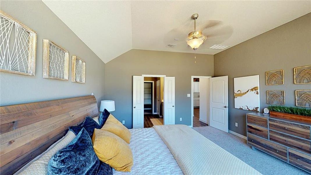Bedroom featuring lofted ceiling, carpet floors, and a ceiling fan Bedroom featuring lofted ceiling, carpet floors, and a ceiling fan
