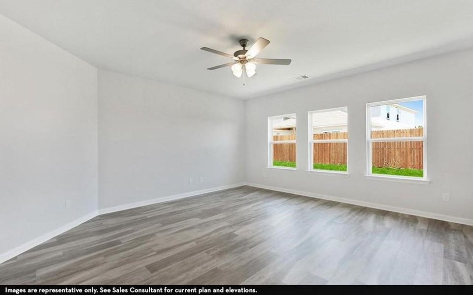 Unfurnished room featuring wood finished floors, ceiling fan, baseboards, and visible vents