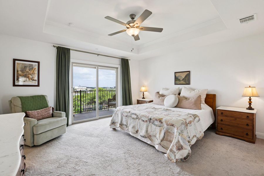 This room features a high ceiling with a tray detail and a ceiling fan