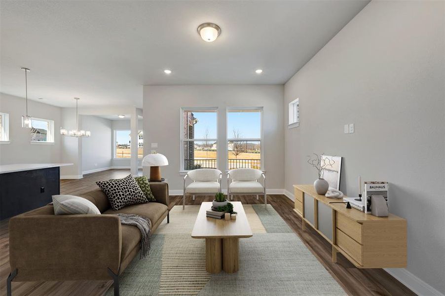 Living area featuring dark wood-style floors, healthy amount of natural light, and a chandelier