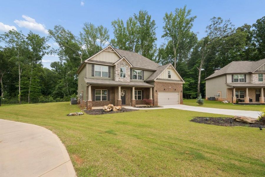Front exterior of a new home in Nine Oaks, Locust Grove, GA, highlighting curb appeal (Image 1). Front exterior of a new home in Nine Oaks, Locust Grove, GA, highlighting curb appeal (Image 1).