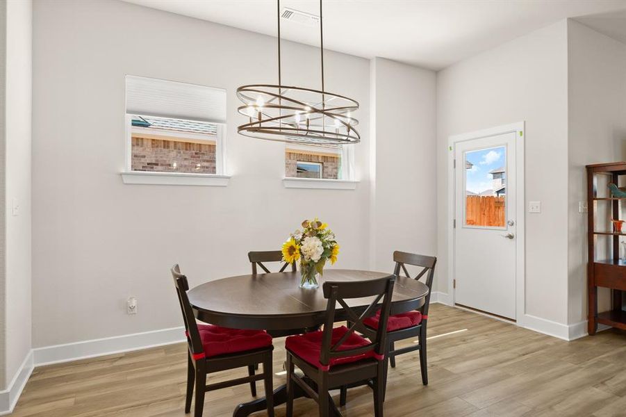 Gather around the chic dining area, illuminated by a stylish modern chandelier, offering the ideal setting for family meals and gatherings.