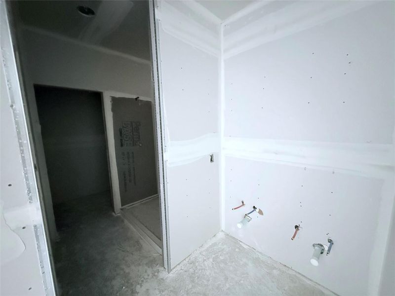 primary bathroom with double sink vanity, walk in closet and walk in shower