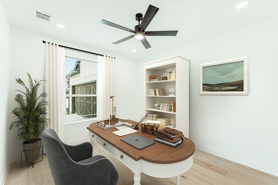 Home office with wood desk, white bookcase, ceiling fan, and light hardwood floors