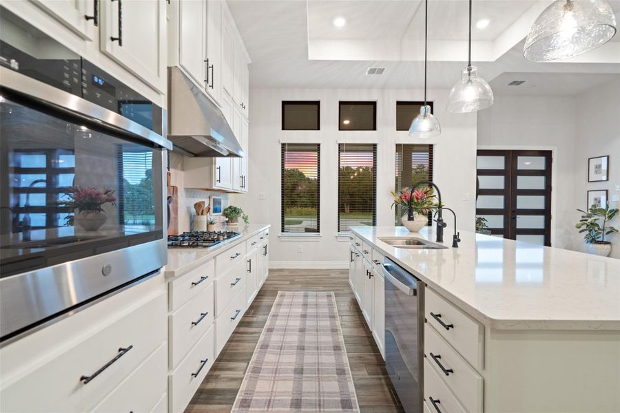 A well-appointed kitchen features sleek countertops, contemporary lighting, and abundant natural illumination. A well-appointed kitchen features sleek countertops, contemporary lighting, and abundant natural illumination.
