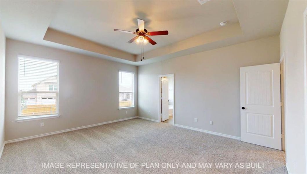 Unfurnished bedroom with a raised ceiling, light colored carpet, connected bathroom, and ceiling fan Unfurnished bedroom with a raised ceiling, light colored carpet, connected bathroom, and ceiling fan