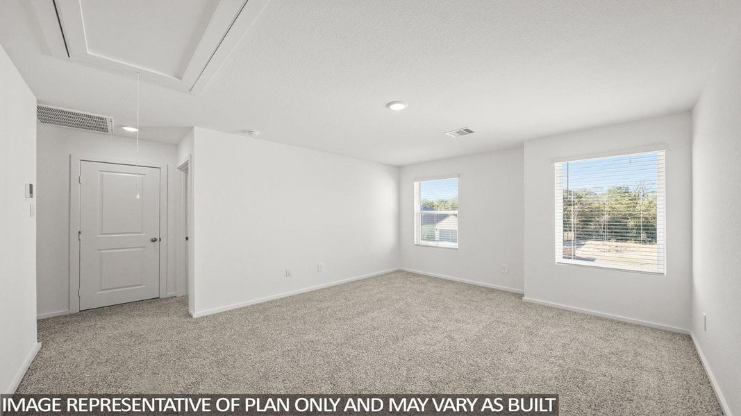 An airy secondary bedroom boasts soft carpeting and two well-lit windows overlooking natural scenery.