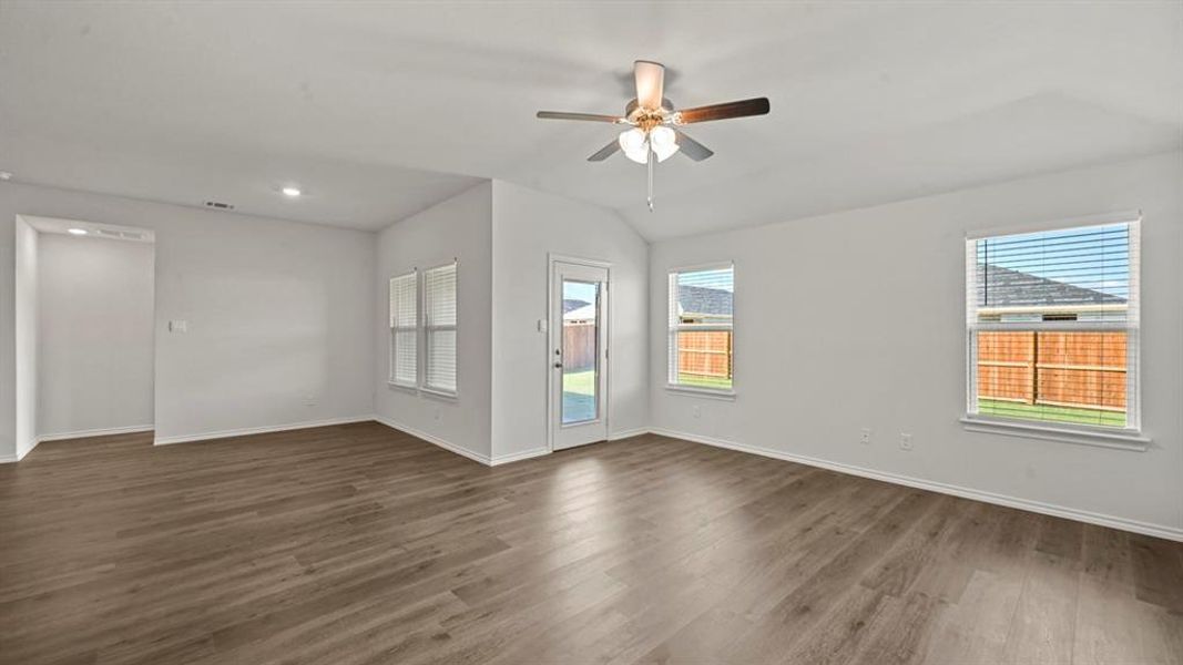 Unfurnished room with ceiling fan, plenty of natural light, dark wood-type flooring, and lofted ceiling