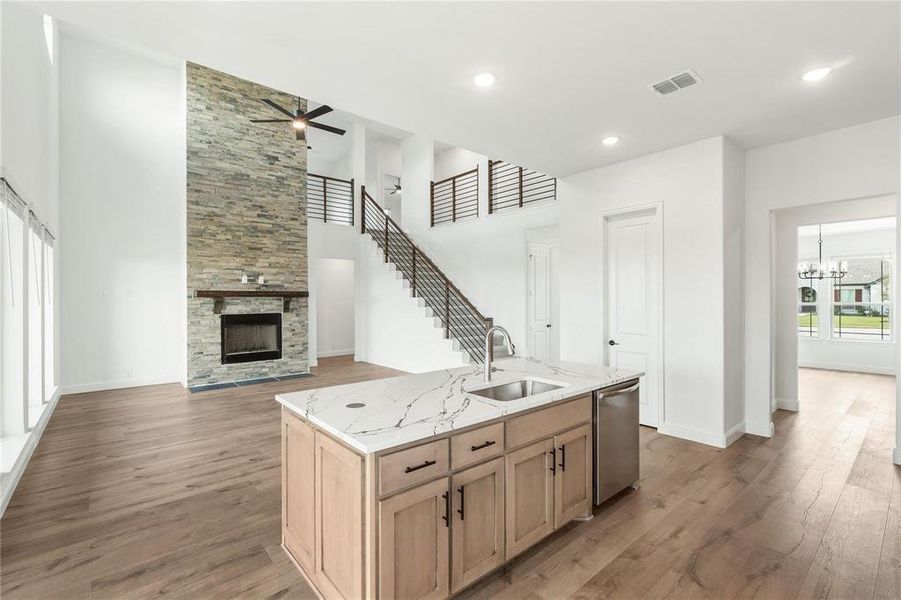 The large central island features quartz countertops and natural woodwork.