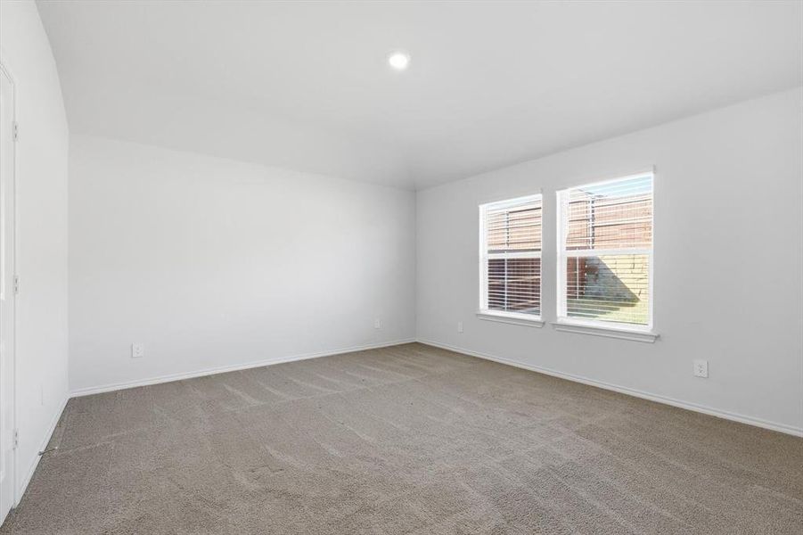 Carpeted room featuring baseboards, recessed lighting and windows with backyard view Carpeted room featuring baseboards, recessed lighting and windows with backyard view