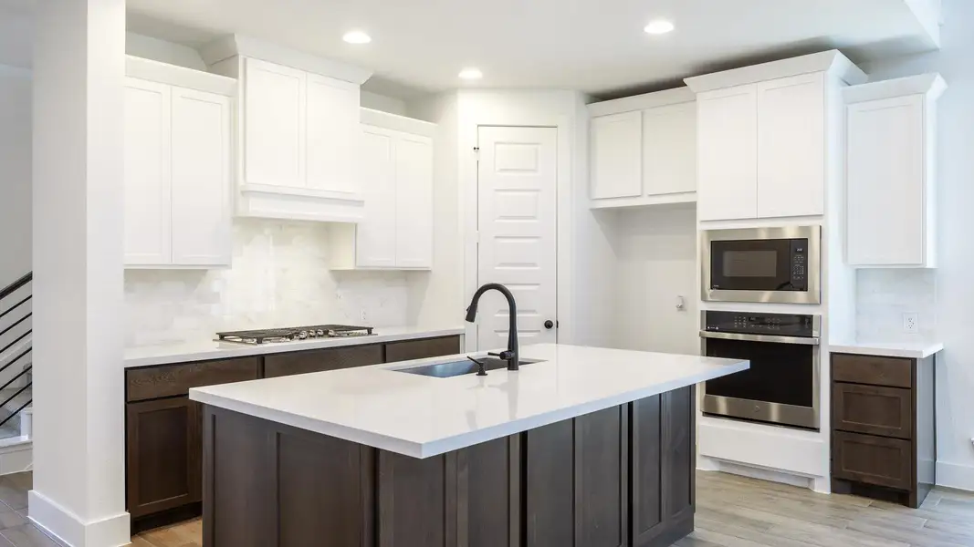 Kitchen with stainless steel appliances, light wood-type flooring, a sink, and decorative backsplash Kitchen with stainless steel appliances, light wood-type flooring, a sink, and decorative backsplash