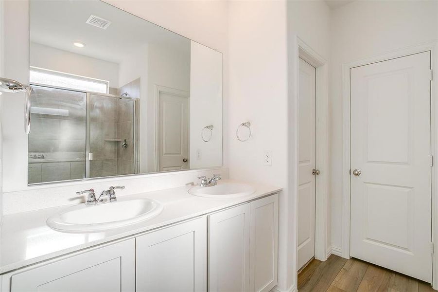 Bathroom featuring vanity, wood-type flooring, and a shower with shower door