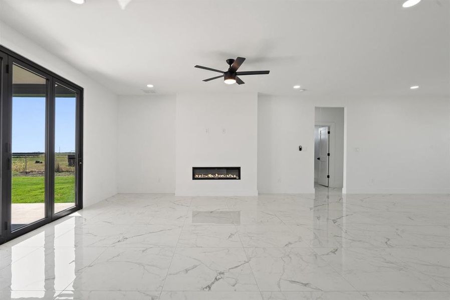 Unfurnished room featuring ceiling fan and a wealth of natural light