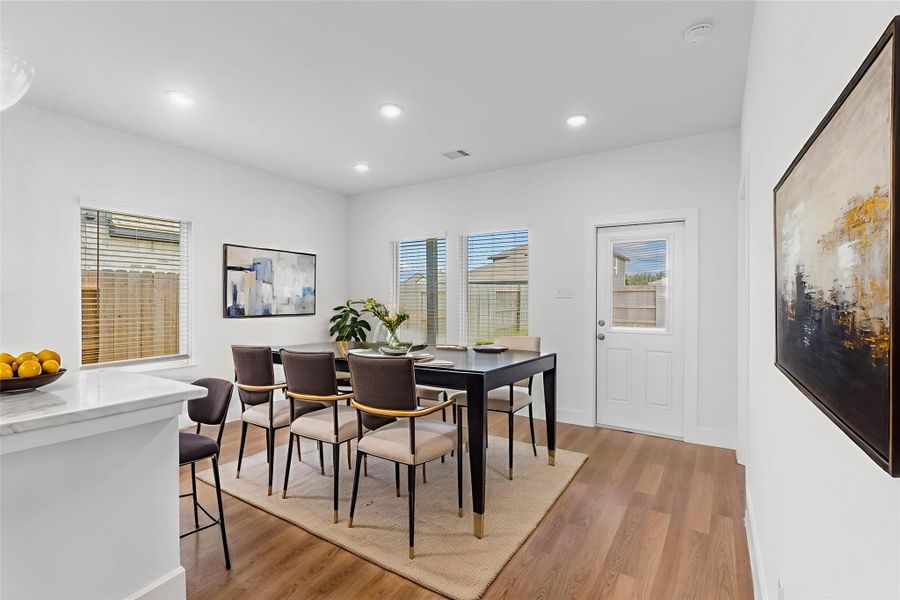 Bright casual dining area with rear yard views and direct patio access, ideal for indoor-outdoor living. *Virtually Staged*