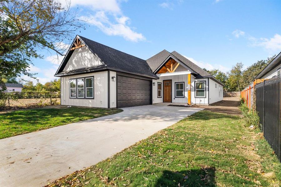 Modern farmhouse style home featuring a front yard and a garage