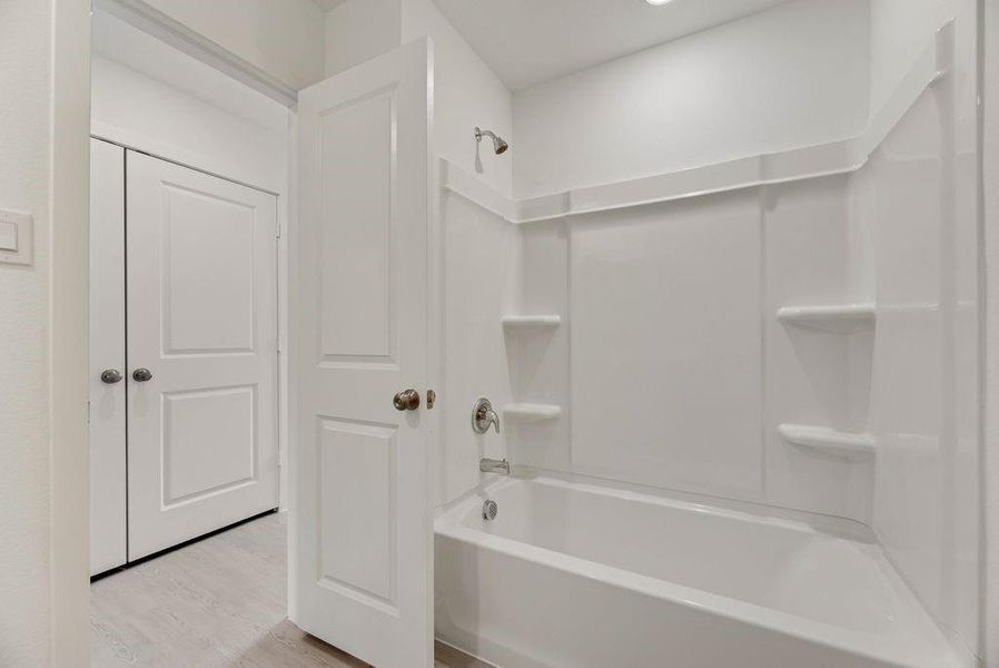 Bathroom with  shower combination and light wood-style floors